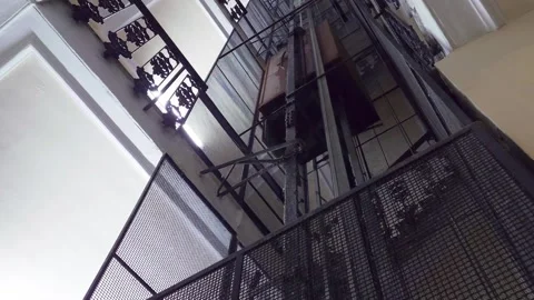 Looking up the old vintage elevator ascending and going up through the Stock Footage 277257347