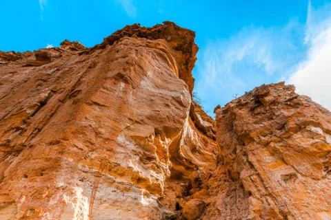 Looking up at orange eroding sandstone cliffs and blue sky in South Australia Stock Photos