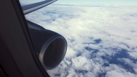 Looking out the airplane window at the engine and wing flying over the atlantic Stock Footage 124217907