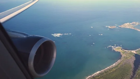 Looking out the airplane window at the engine and wing while landing in San Juan Stock Footage 124219007