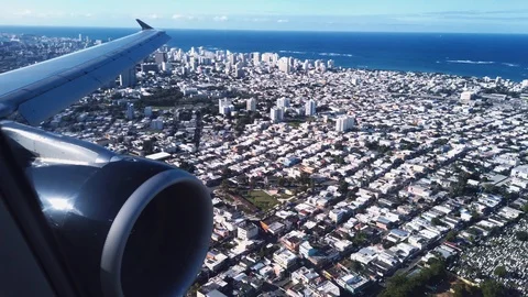 Looking out the airplane window at the engine and wing while landing in San Juan Stock Footage 124219474