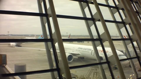 Looking out to the apron runway with cranes and repairing airplanes Stock Footage 157967344
