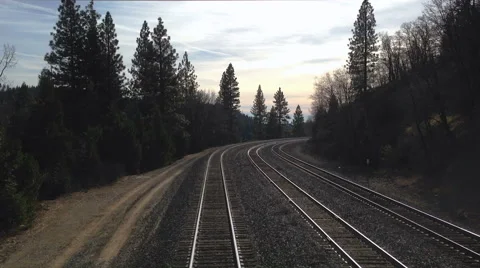 Looking out the back of a train going into mountain with sunset or sunrise sky Stock Footage 45091510
