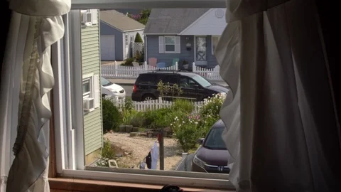 Looking out beach style house window with curtains blowing Stock Footage 95689368
