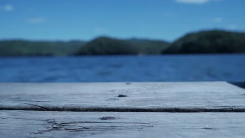 Looking out at a blue river from a small wood ship dock Stock Footage 75386390