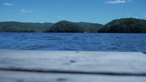 Looking out at a blue river from a small wood ship dock 库存影片 75386559