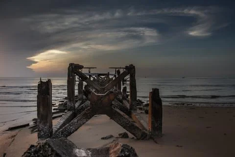 Looking out at Broken old structure remains of pier  in the during beautiful Stock Photos