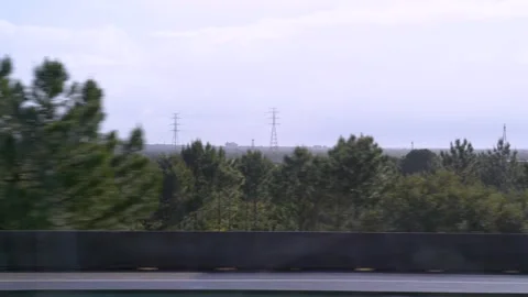 Looking out a car window from highway on solar field and power lines Stock Footage 273674208