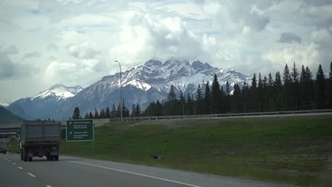 Looking out car window at snow covered mountains in summer Vídeo Stock 244946951