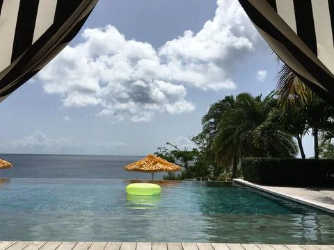 Looking out at the Infinity pool under a striped cabana Stock Photos