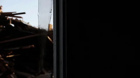 Looking out from the inside of a building at a pile of trash Stock Footage 95110636