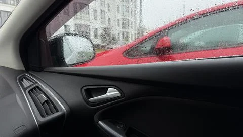 Looking out from inside a car on a rainy day. The black interior door panel is Stock Photos