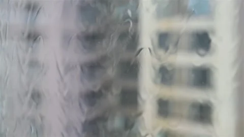 Looking out to a multilayered building through glass in a raining day Stock Footage 244034926
