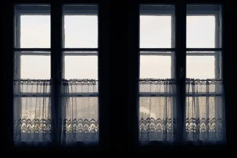 Looking out the old windows with half curtains from inside of dark room Stock Photos