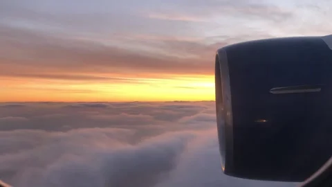 Looking Out Passenger Plane window To Dawn and Clouds Below Stock Footage 252539480