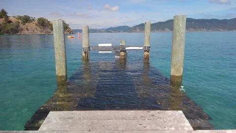 Looking out from a pier into a scenic bay Stockbeeldmateriaal 125115404