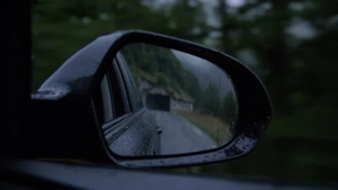 Looking out the side car mirror as the car drives on highway in the rain. Stockbeeldmateriaal 290266927