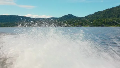 Looking out from the stern of a fast moving motor boat to it's large bright 스톡 동영상 277999749