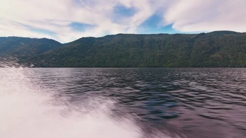 Looking out from the stern of a fast moving motor boat to it's large bright Stock Footage 277999898