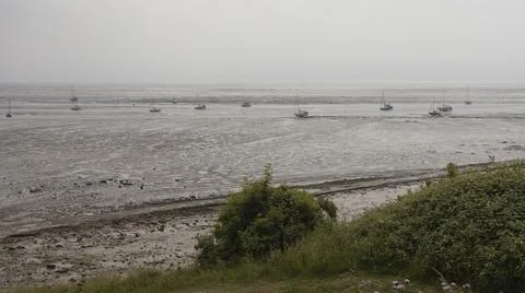 Looking out through grass at beached boats Stock Photos