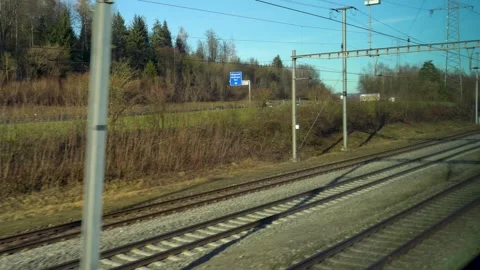 Looking out a train on highway and train tracks while travelling Stock Footage 263815614