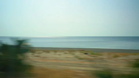 Looking out the train window in Calabria at the sea and the sandy beach Stock Footage 340272081