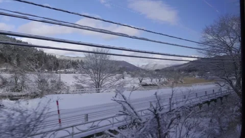 Looking out of train window in Japan with rural winter scenery in distance Stock Footage 327630719