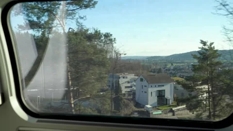 Looking out of a train window on trees and hills with train passing Stock Footage 263815667
