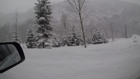 Looking out the window of a car driving in the snowy countryside Stock Footage 99944745