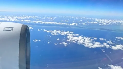 Looking out of window of flying at sunrise airplane. Point of view 4k video  Stock Footage 265889479