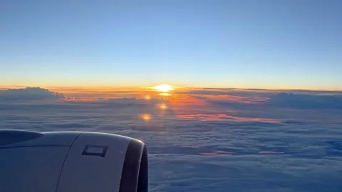 Looking out of window of flying at sunrise airplane. Point of view 4k video  Stock Footage 265889499