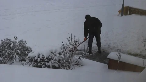 Looking out of window at man shoveling snow Stock Footage 83409567
