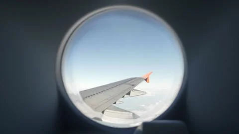 Looking out the window of a plane to the aircraft wing, blue sky and clouds Stock Footage 149322631
