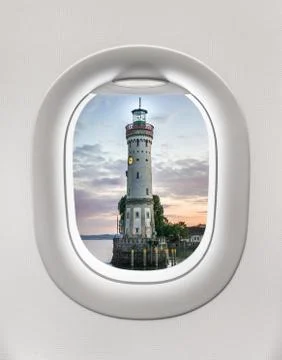 Looking out the window of a plane to the lighthouse in Lindau, Germany Stock Photos
