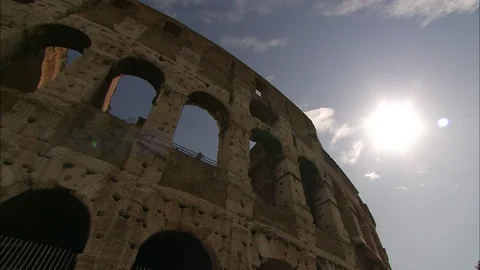 Looking up at outer wall of the Colosseum with sun shining in sky 動画素材 95603122