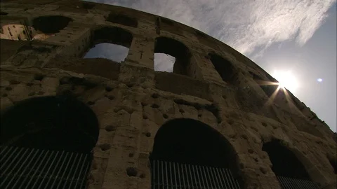 Looking up at outer wall of the Colosseum with sun shine breaking edge of wall Video stock 95603130
