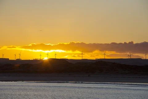 Looking over Beadnell beach towards the Cheviots with a wind farm at sunset,  Stock Photos
