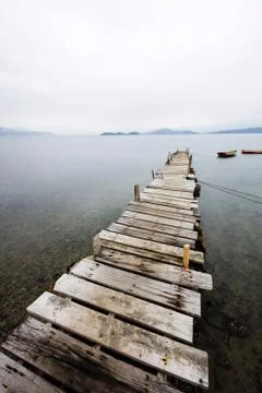 Looking over a desolate peer and a boat. Stock Photos