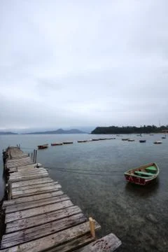 Looking over a desolate peer and a boat Fotos Stock