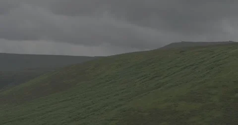 Looking over green fields with moody clouds Stock Footage 277230334