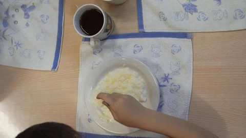 Looking over head. The boy eats porridge in kindergarten. Stock Footage 99729473
