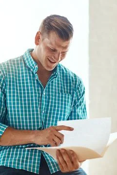 Looking over his creative brief. a handsome young businessman looking over some Stock Photos