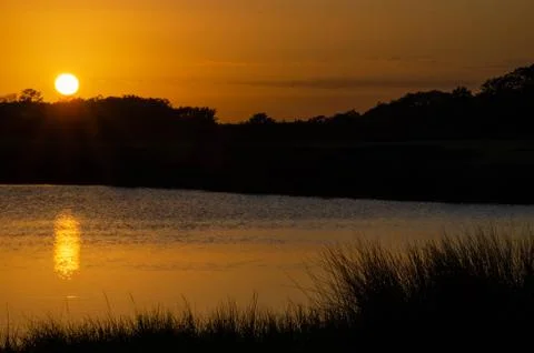Looking over the marsh of the setting sun on Oak Island NC Stock Photos