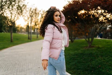 Looking over the shoulder of someone looking in the park is a beautiful girl in Stock Photos