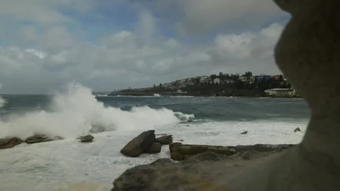 Looking past rugged coatal area to Coogee in Sydney 6K Stock Footage 305514730