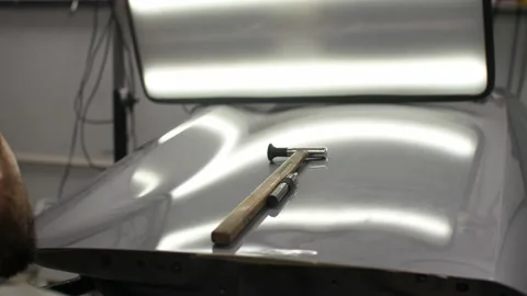 Looking on the perfect silver colored car surface with hammer after using PDR Video stock 152503627