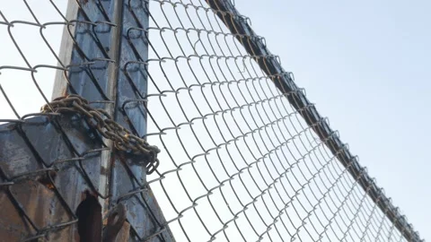 Looking up perspective of weathered chain link fence Stock Footage 328335579