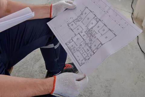 Looking at the plan of the apartment for renovation Stock Photos