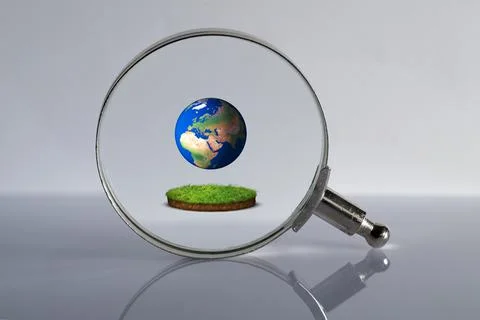 Looking at the planet earth through a magnifying glass Stock Photos