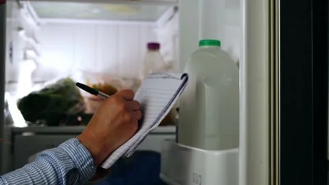 Looking in the refrigerator and making shopping list Stock Footage 204867518